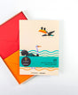 Pack of writing paper with toucan design and red envelope on white background