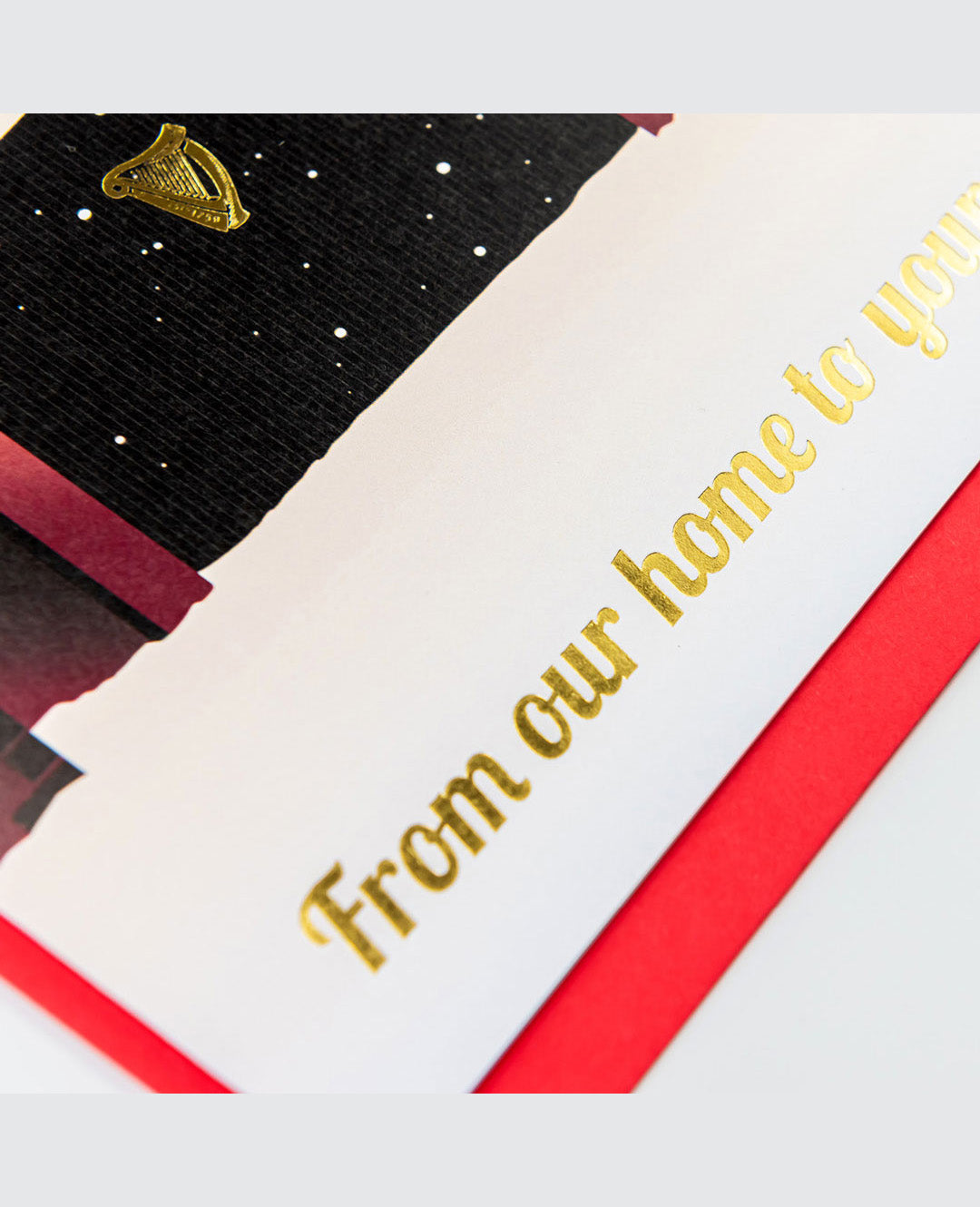 Greeting card with 'From our home to yours' text on a red, white, and black striped background.