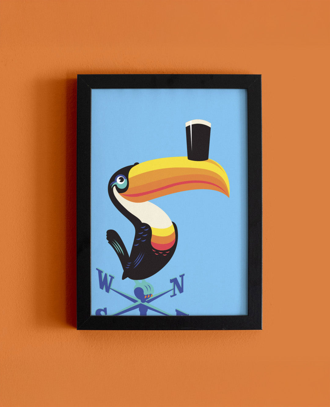 Framed artwork of a colorful toucan on an orange wall