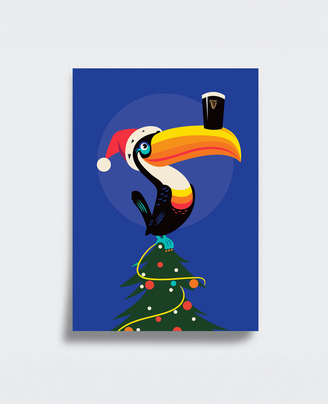 Colorful toucan in a Santa hat holding a pint glass on a Christmas tree against a blue background