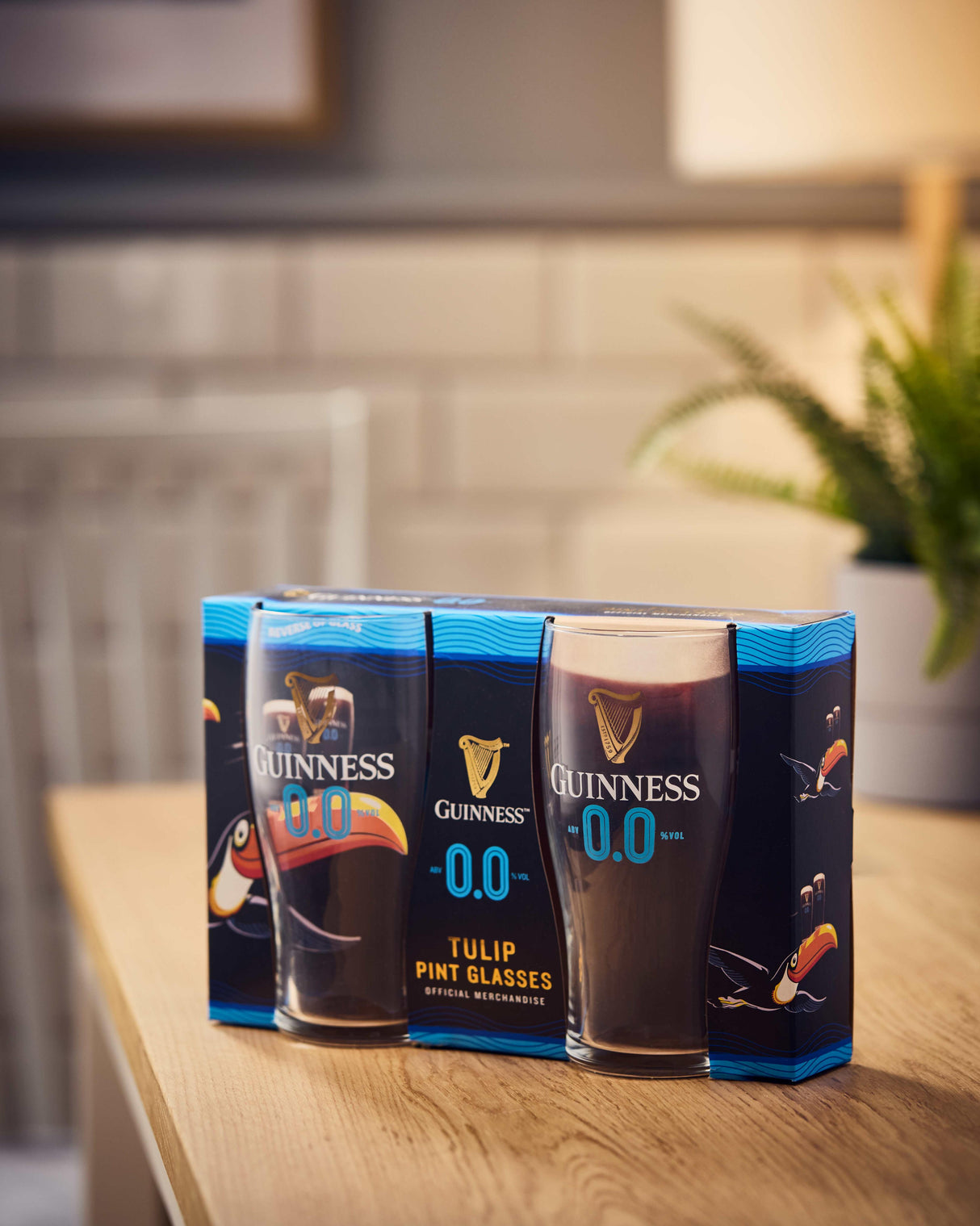 Pack of Guinness 0.0 tulip pint glasses on a kitchen counter.
