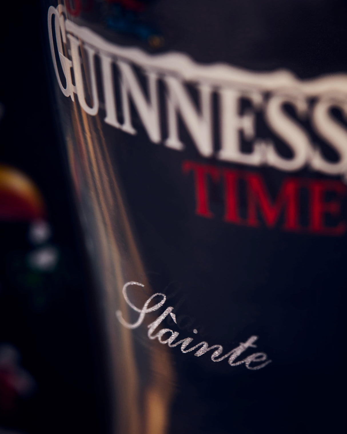 Close-up of a Guinness glass with 'Guinness Time' text on a dark background