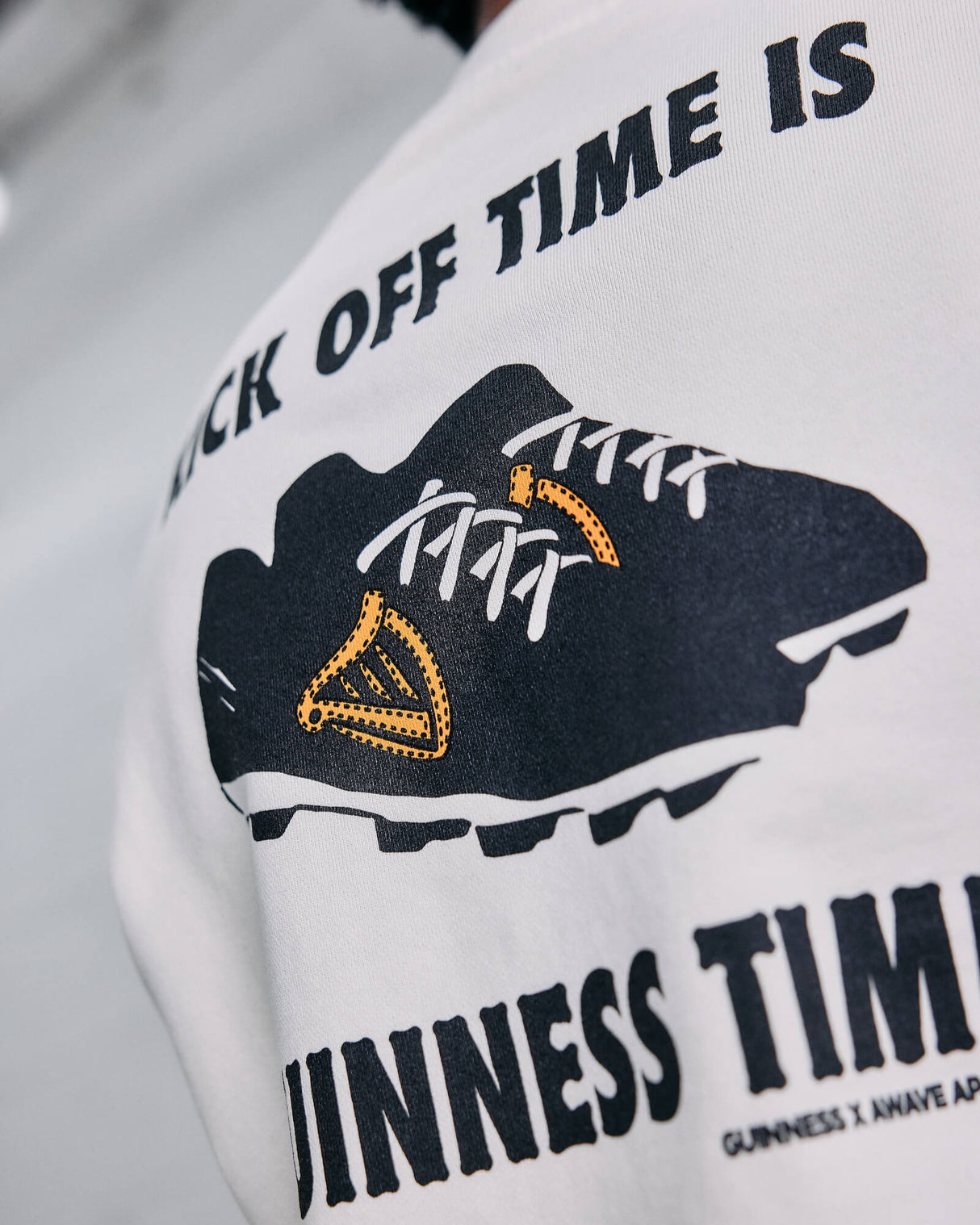 White sweatshirt with black Kick off time is Guinness Time and graphic design on a blurred background