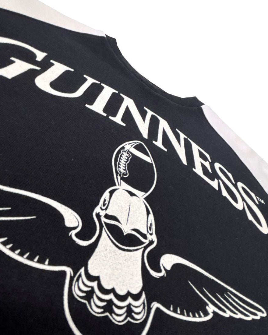 Black shirt with white 'Guinness' logo and winged helmet design on a white background