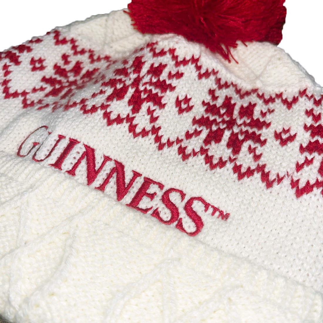 White knit hat with red pattern and 'Guinness' branding on a white background