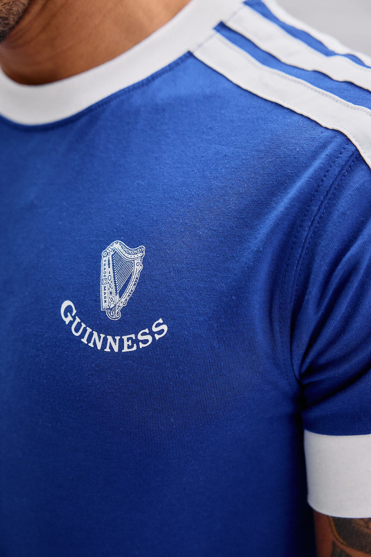 Blue shirt with white collar and Adidas logo, featuring Guinness branding.