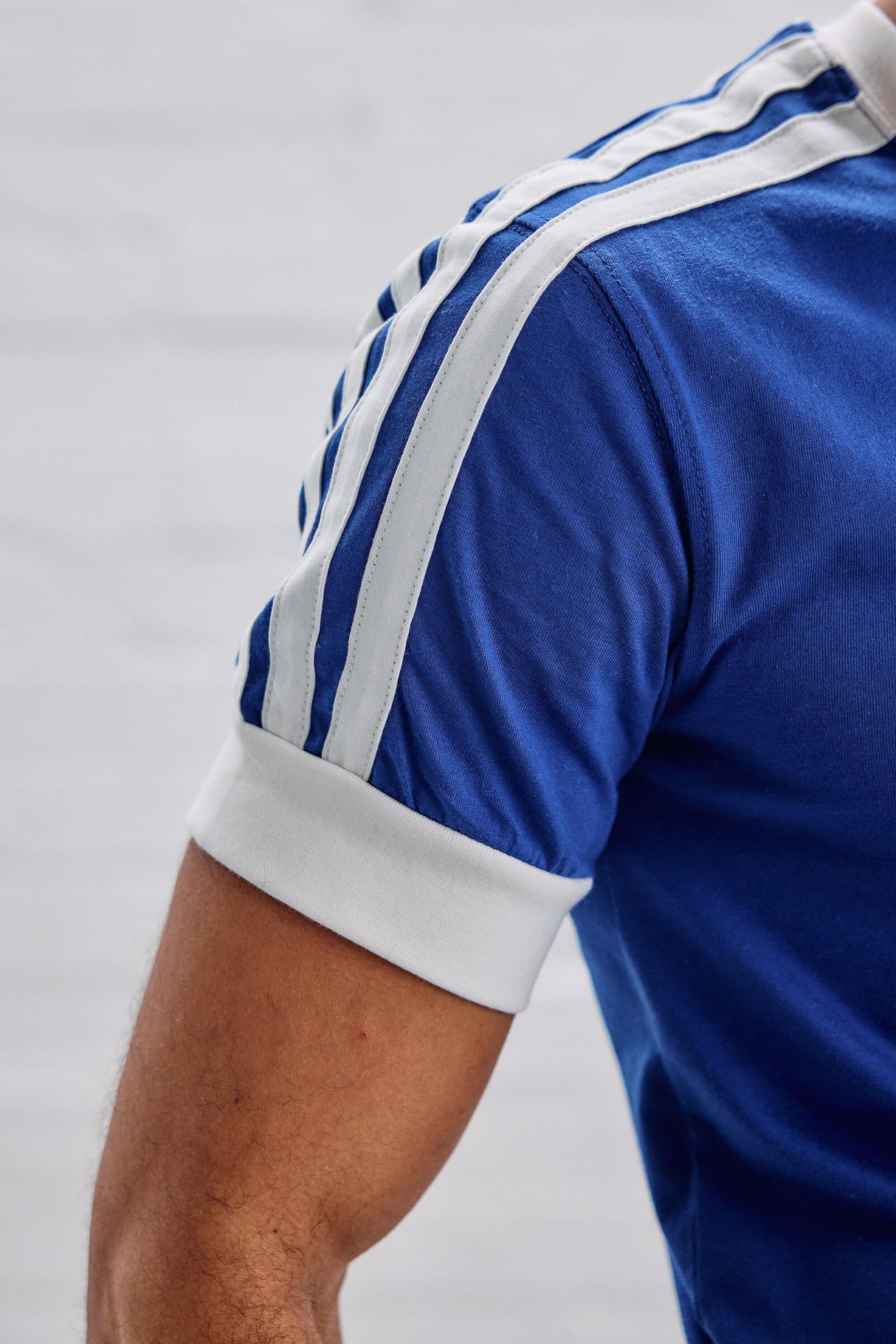 Blue sports jersey with white stripes on a gray background