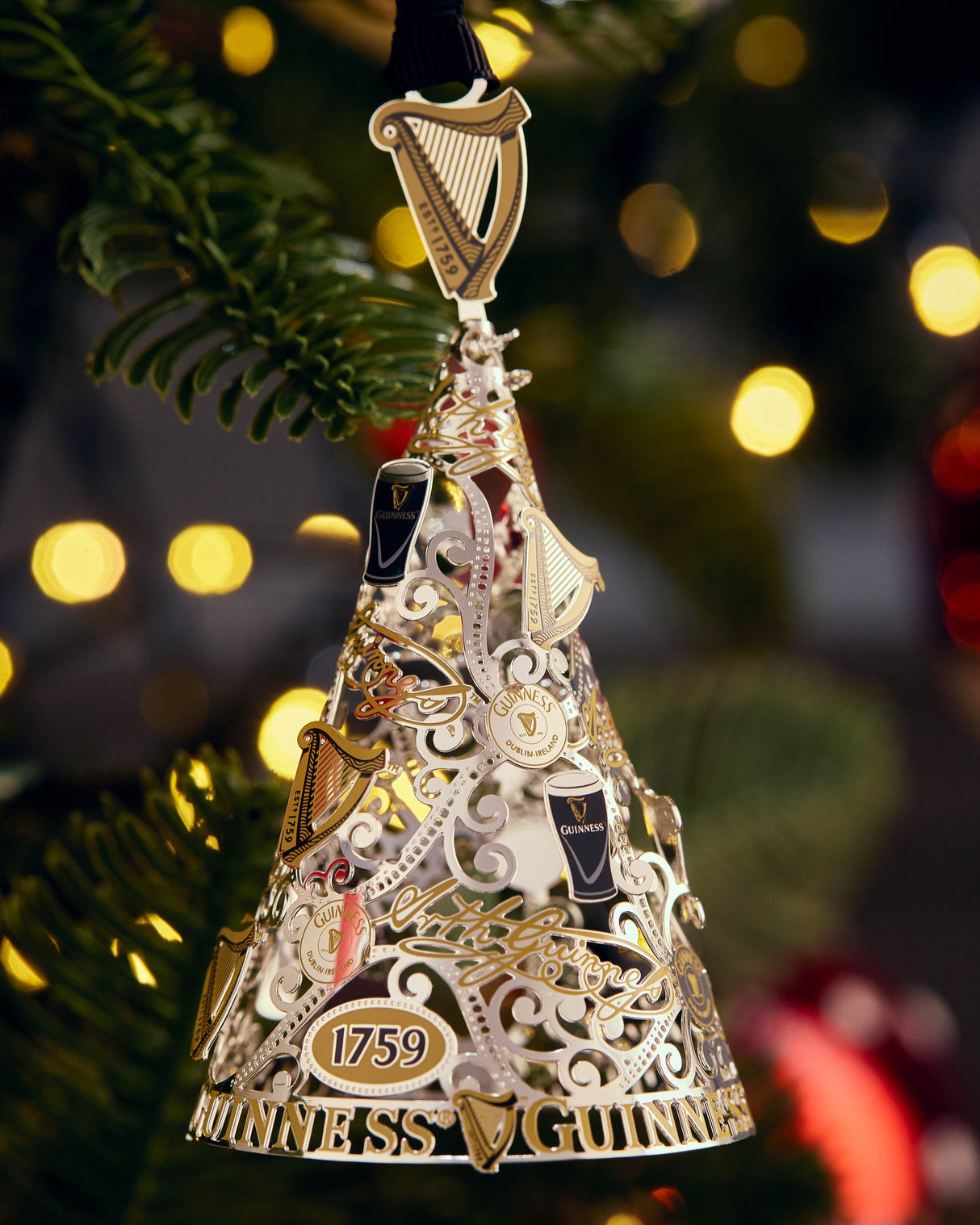 Decorative bell ornament with intricate designs and '1759' marking on a Christmas tree.