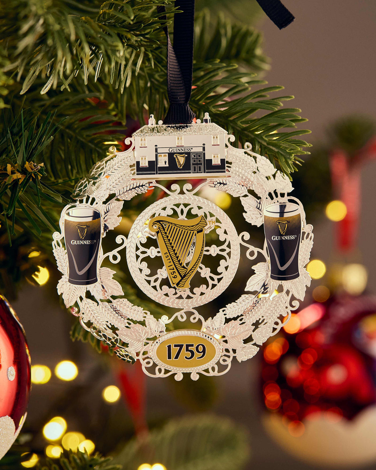 Decorative Christmas ornament with Guinness logo on a Christmas tree.