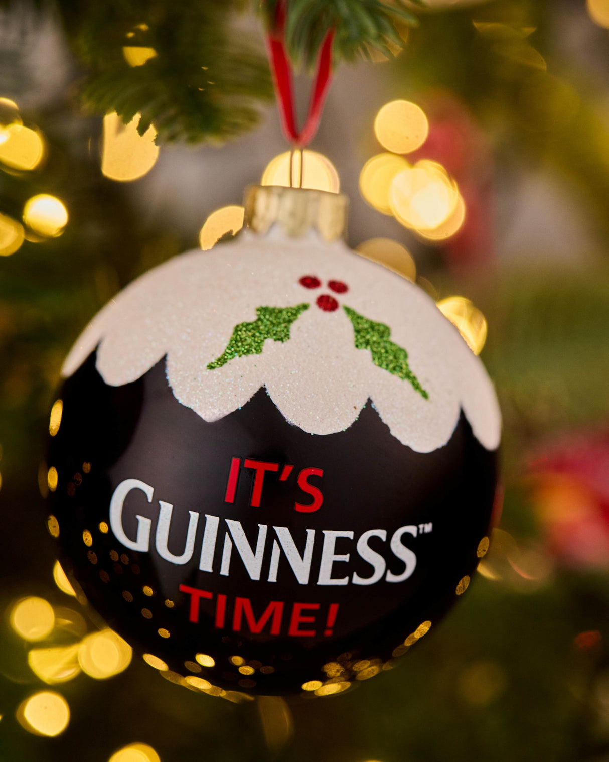 Christmas ornament with 'It's Guinness Time!' text on a decorated tree.