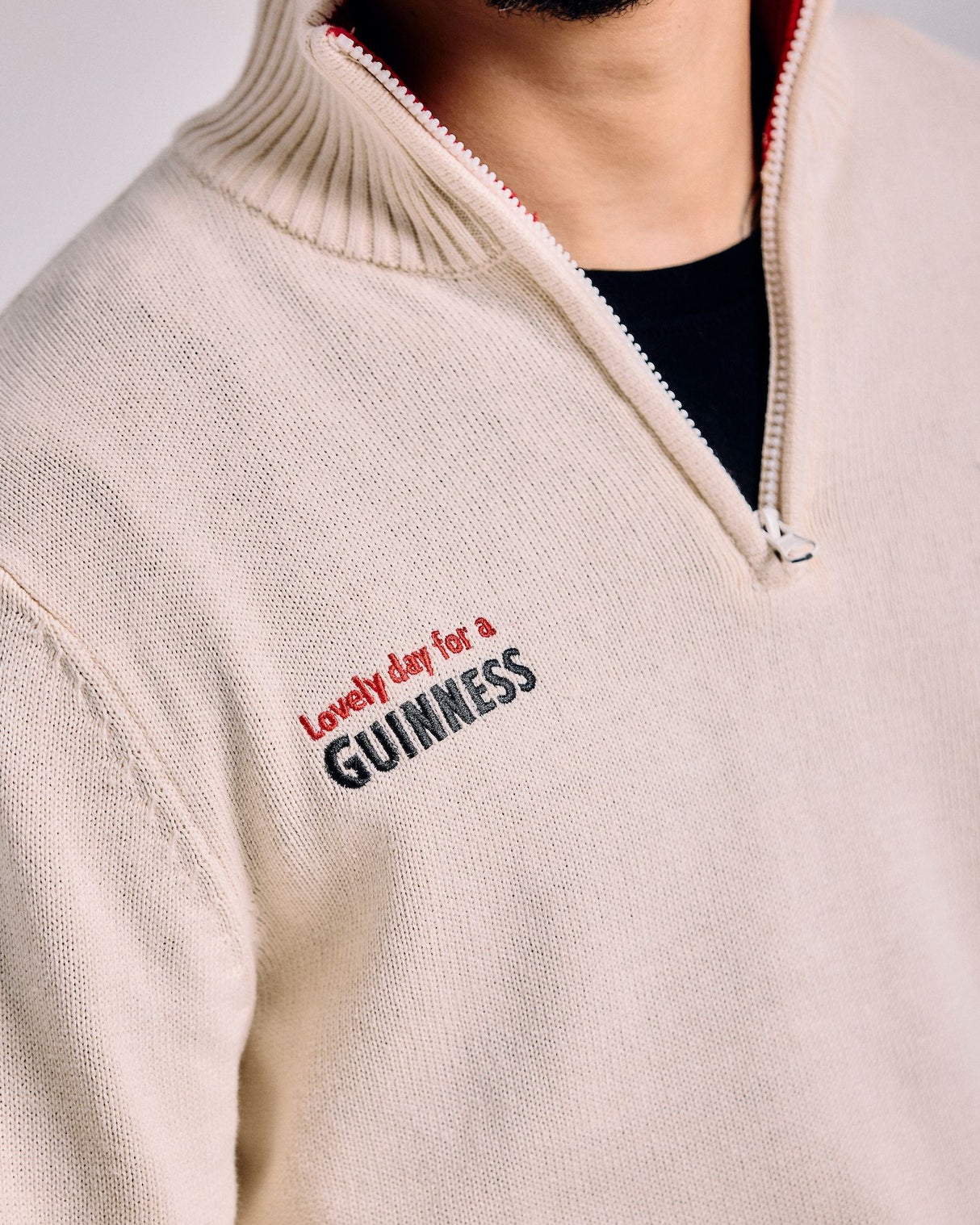 Beige sweater with 'Lovely day for a GUINNESS' text on a plain background