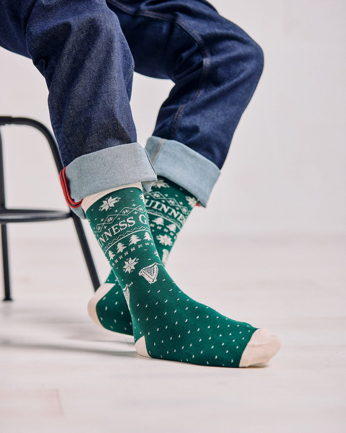 Person wearing green patterned socks with a white background
