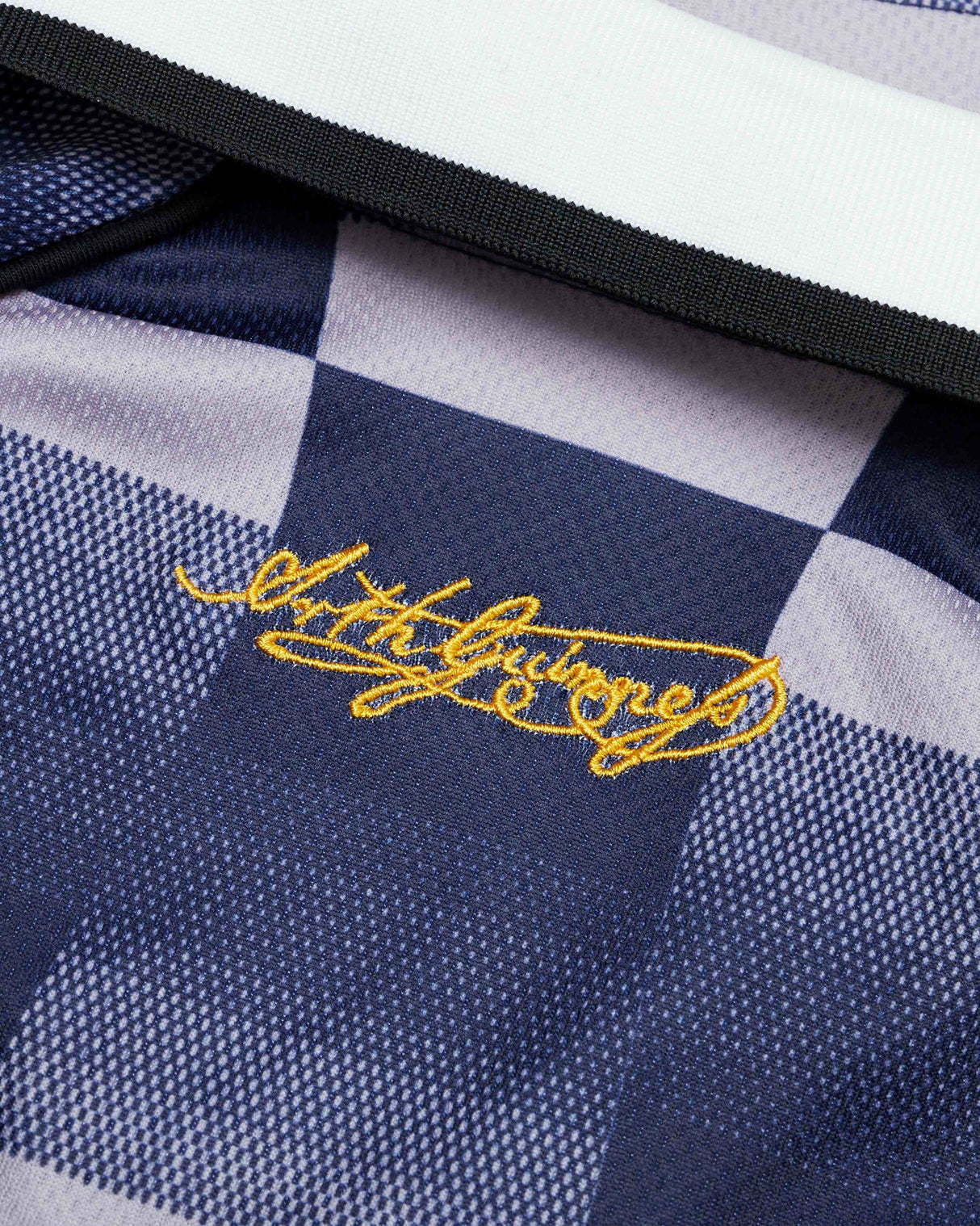 Navy and white checkered fabric with yellow embroidered text on a black border.
