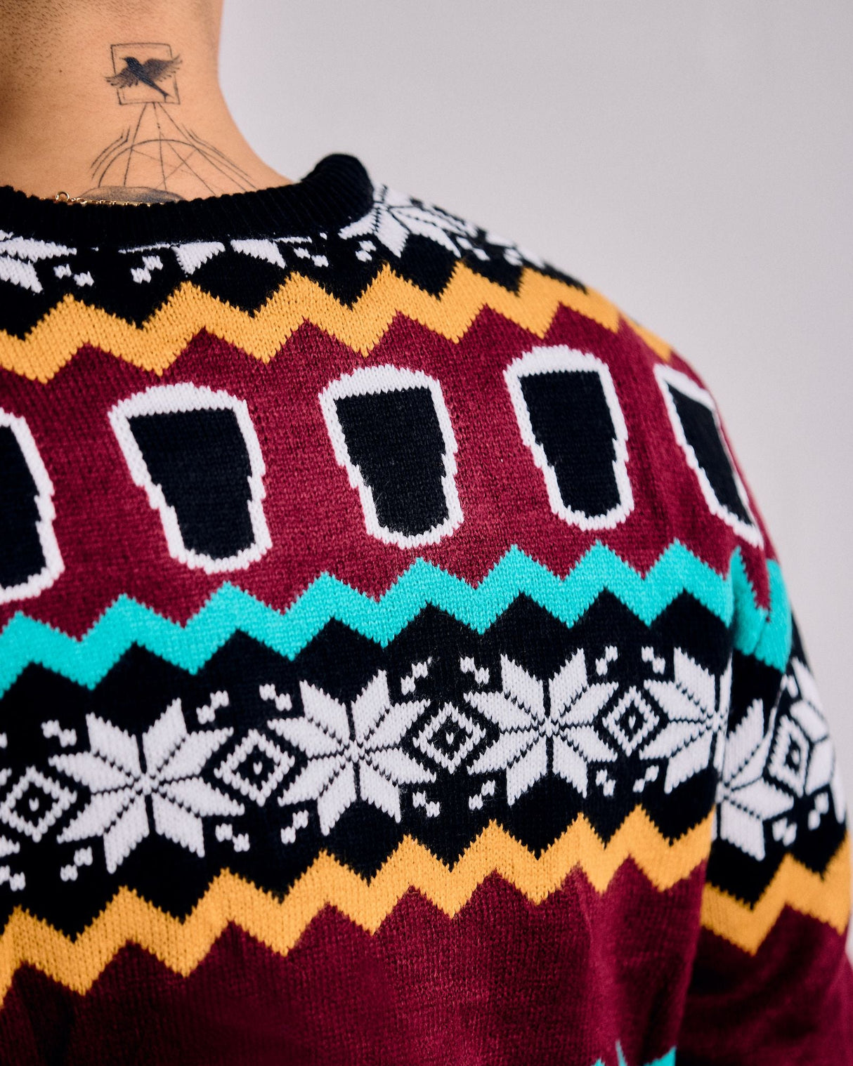 Colorful patterned sweater with geometric designs on a plain background