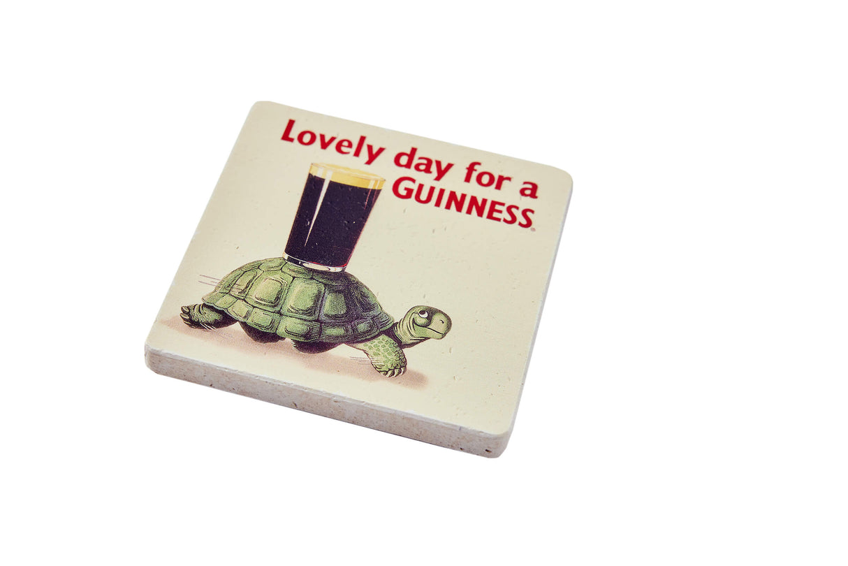 Coaster with turtle holding a Guinness glass and text 'Lovely day for a GUINNESS' on a white background