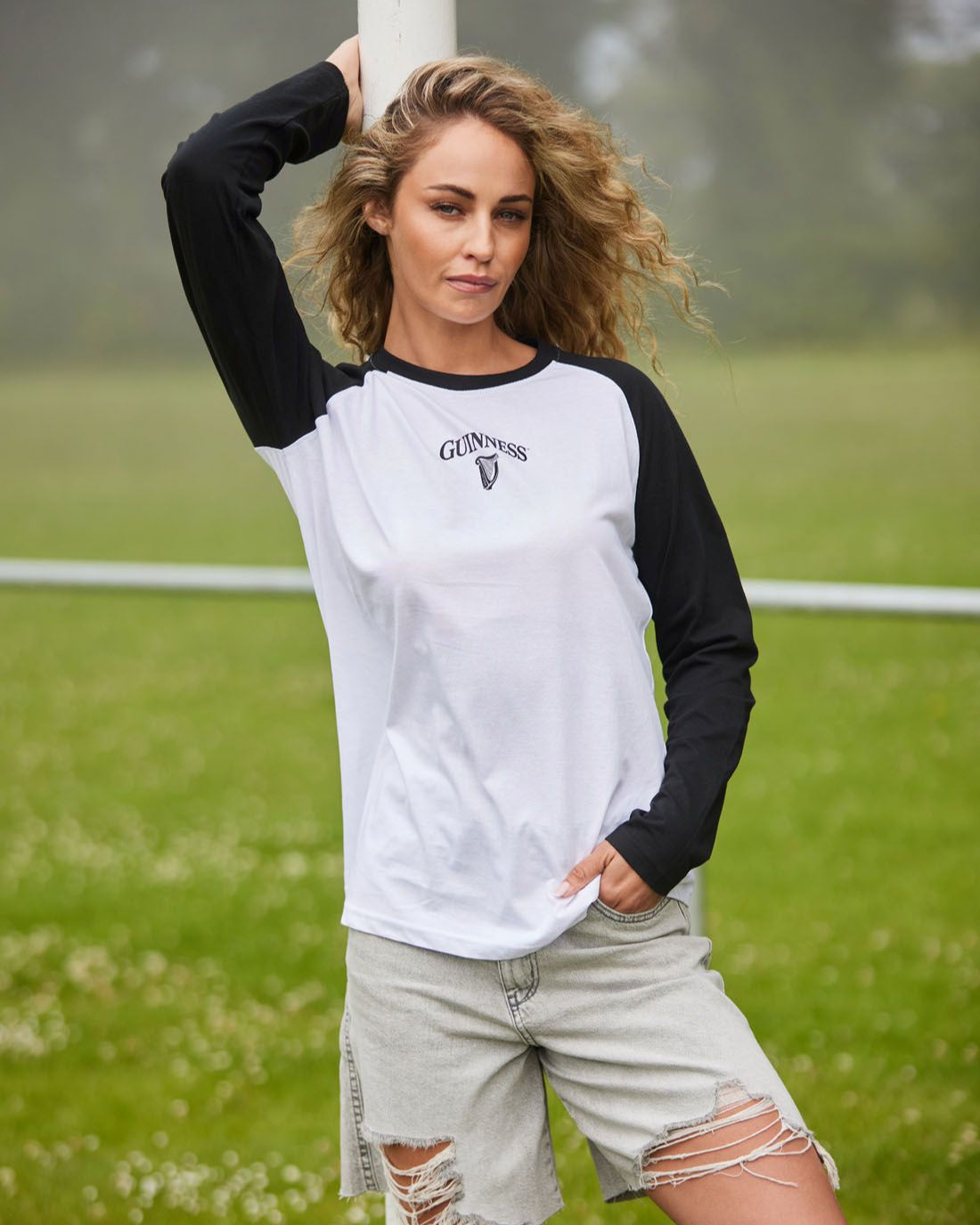 Woman wearing a black and white baseball-style shirt on a grassy field