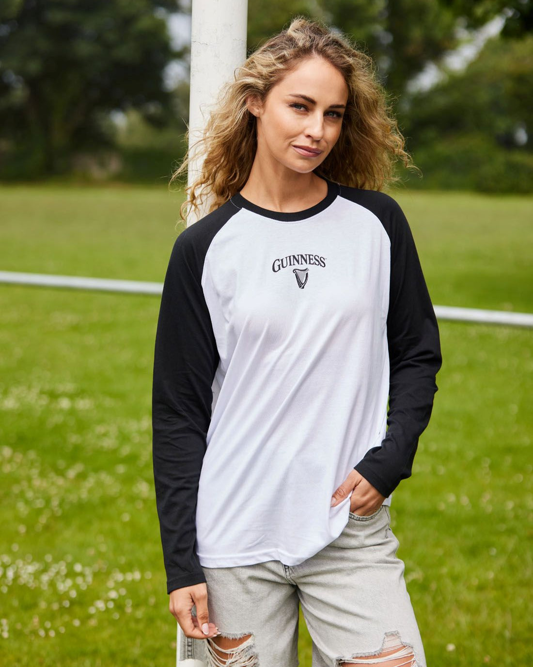 Woman wearing a Guinness baseball shirt on a grassy field