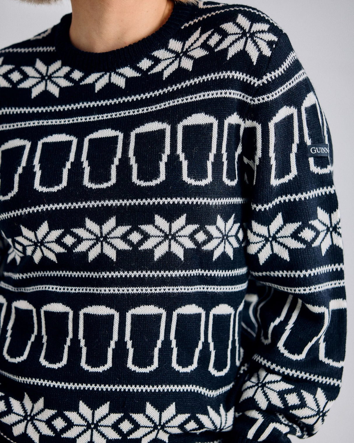 Navy blue sweater with white beer mug pattern on a plain background