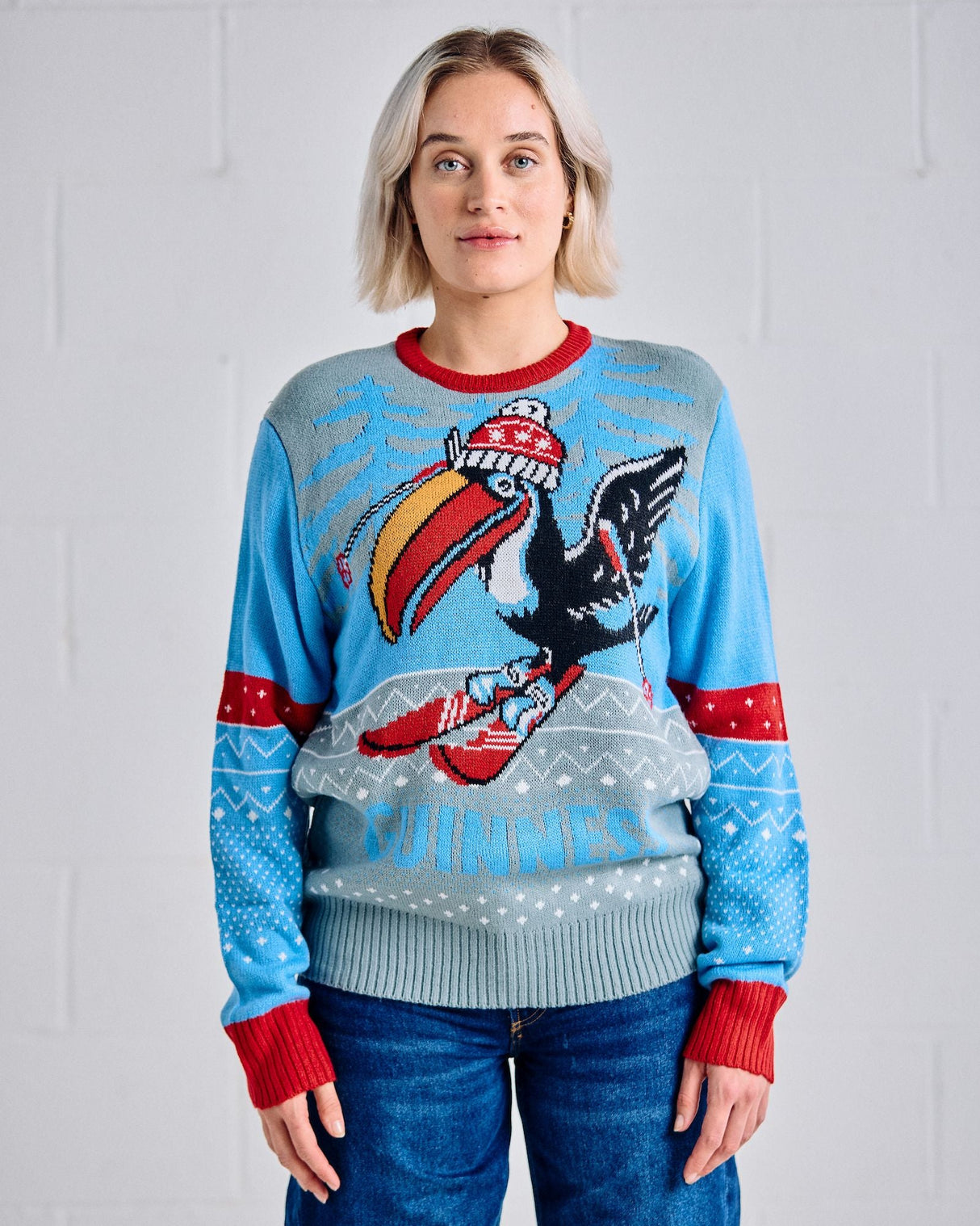 Person wearing a blue sweater with a colorful eagle design against a white background