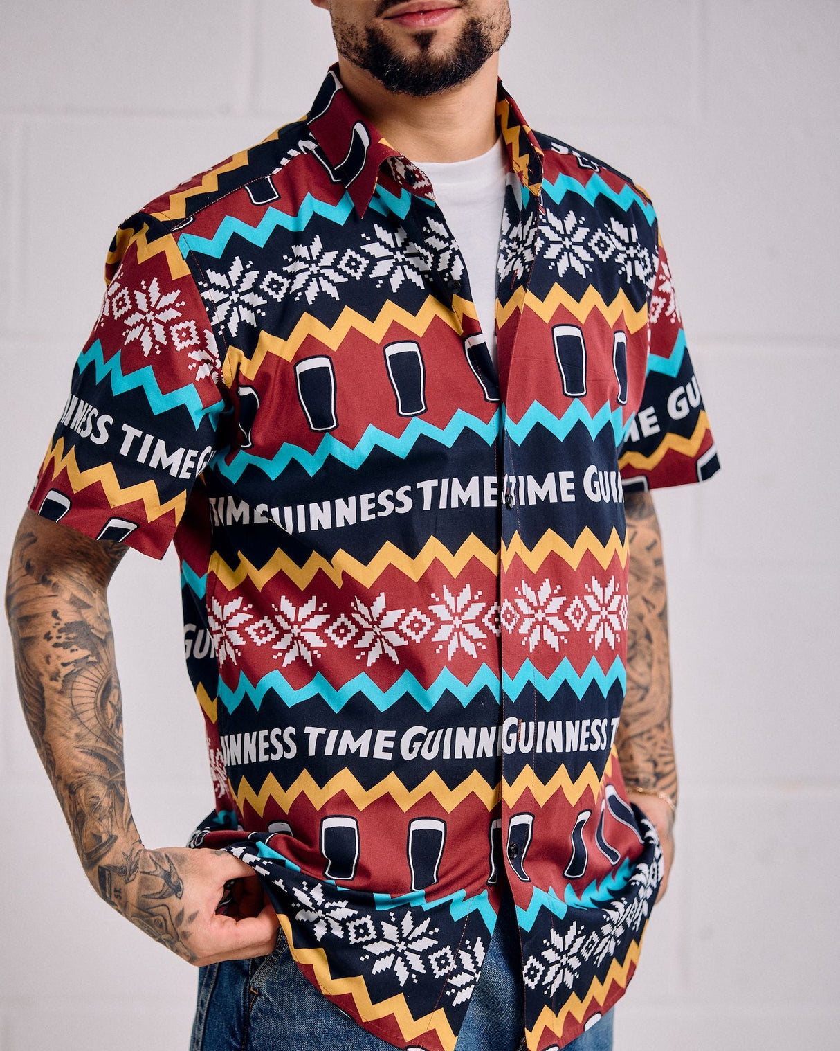 Person wearing a colorful patterned shirt with 'Guinness Time' text on a plain background