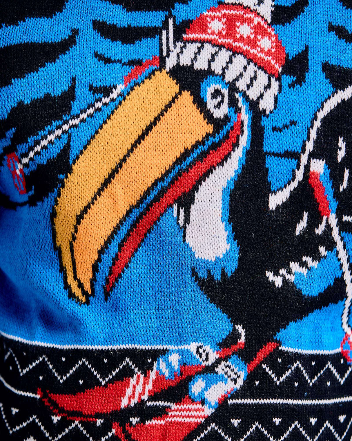 Close-up of a Guinness beer sweater with a toucan design on a blue background.