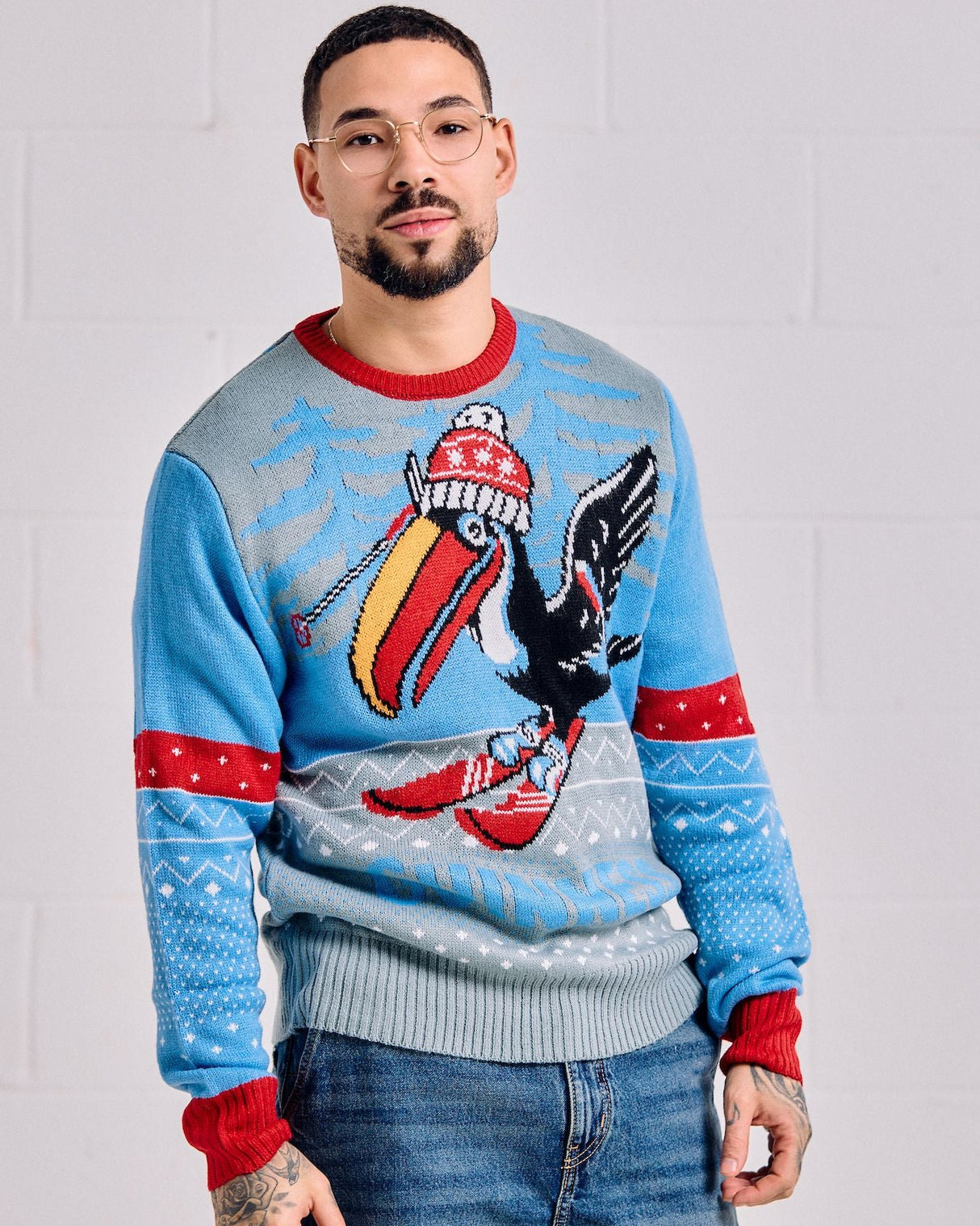 Person wearing a colorful sweater with an eagle design against a plain background