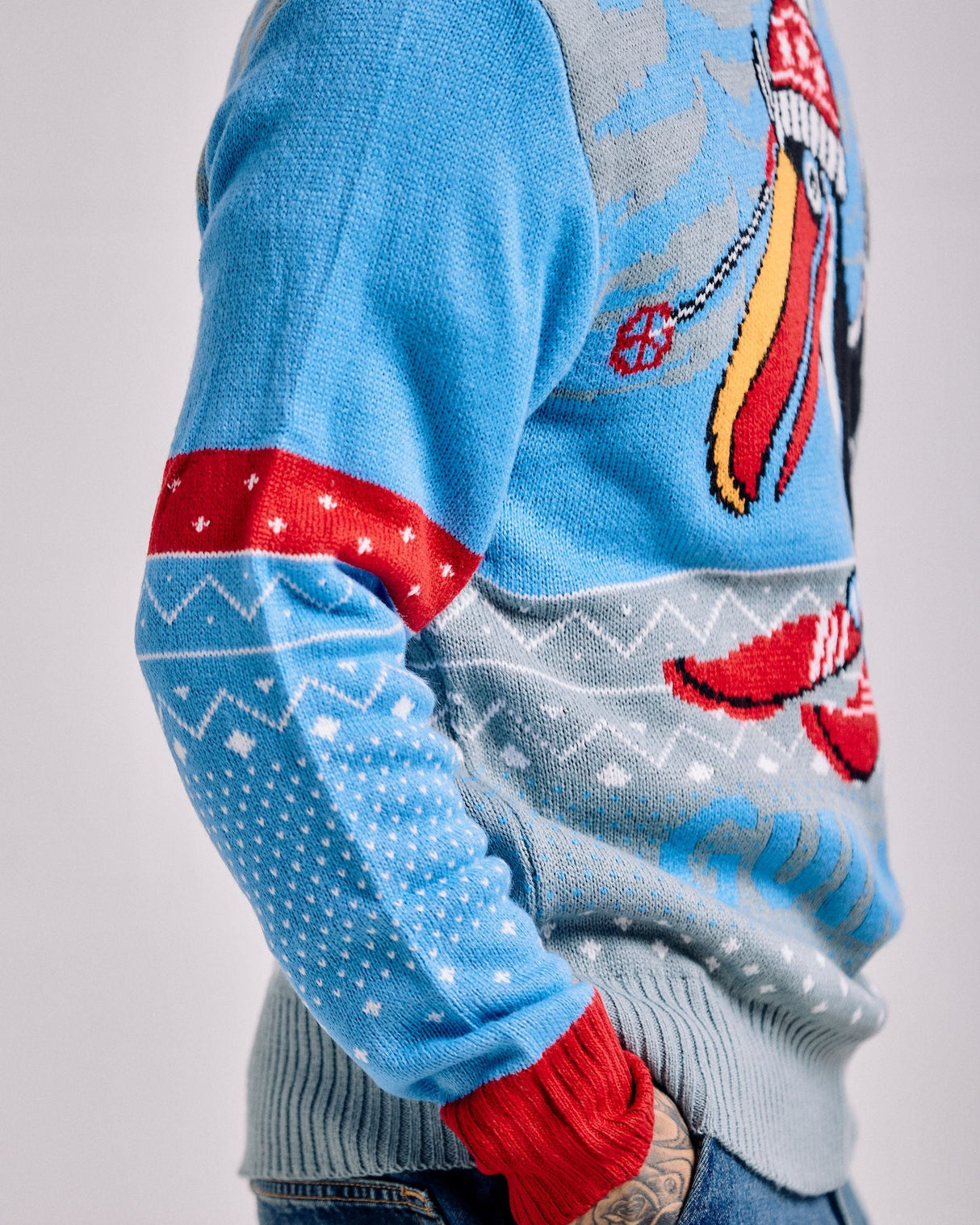 Light blue sweater with red and gray patterns on a plain background