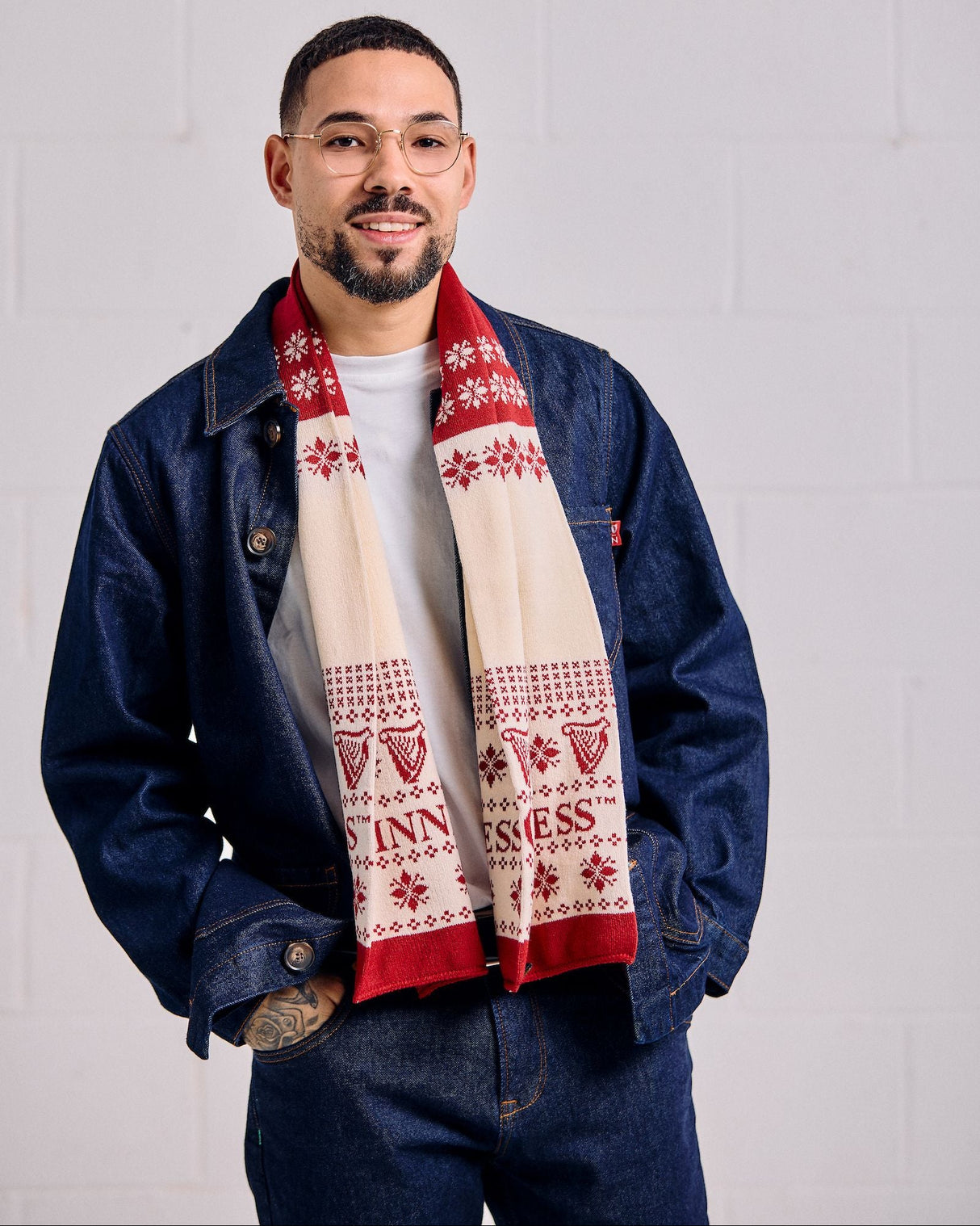 Man wearing a blue jacket and patterned scarf against a white background
