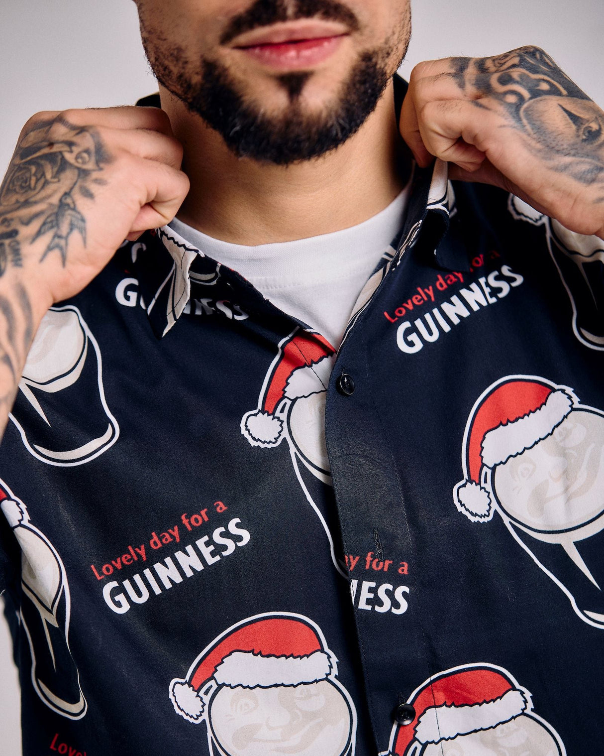 Person wearing a dark blue shirt with Guinness beer graphics and text.