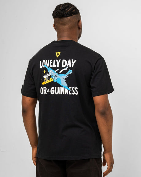 Person wearing a black t-shirt with a graphic design and text on the back, on a plain background