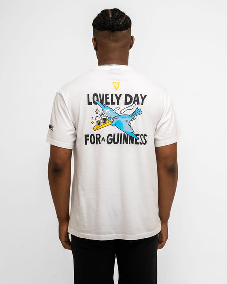 Person wearing a white t-shirt with a graphic and text on the back, standing against a white background