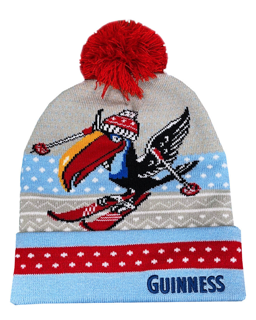 Knitted beanie with a red pom-pom, colorful design, and 'Guinness' branding on a white background.