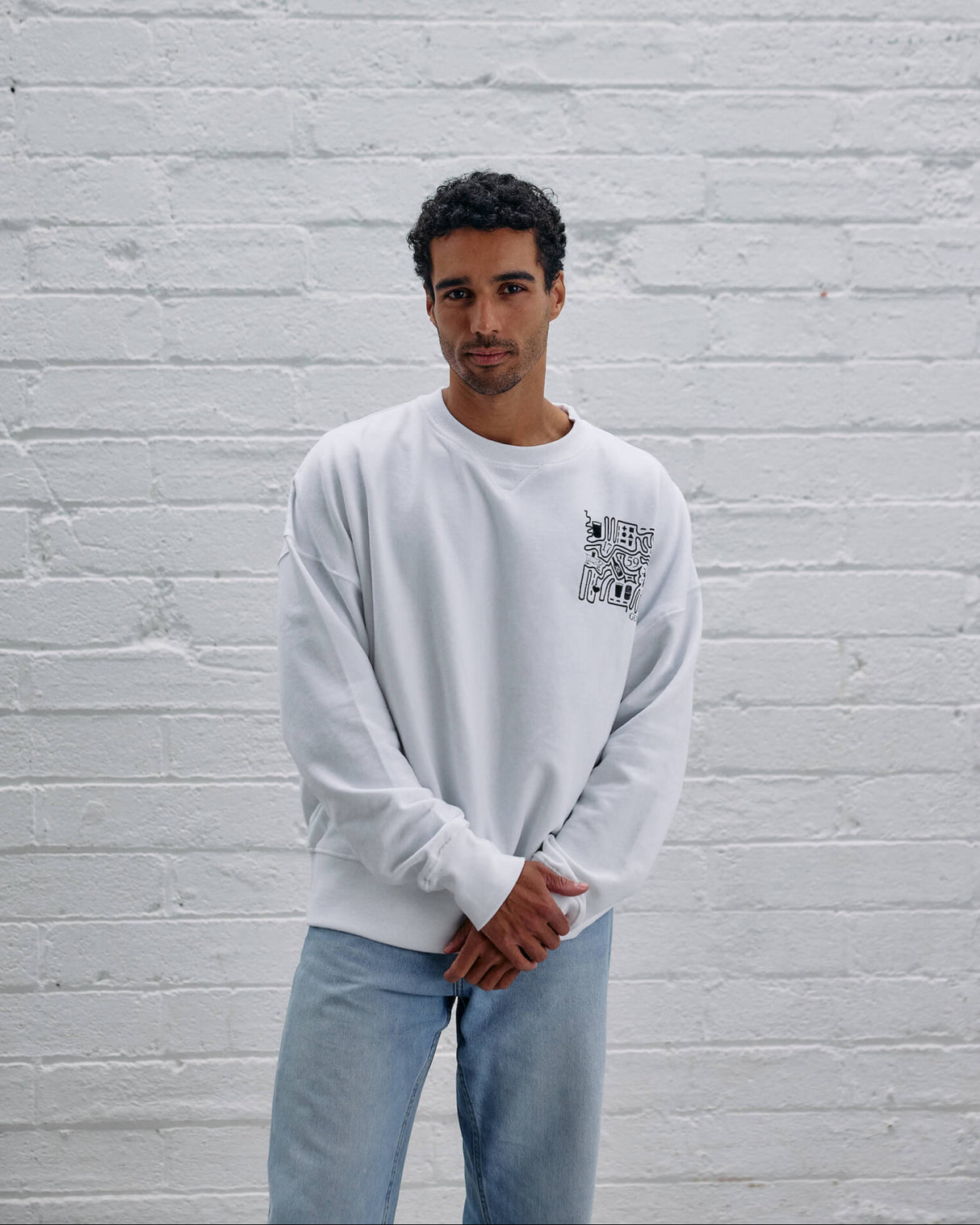 Model wearing the Guinness Storehouse Exclusive white Sweater with stylized Dublin map.