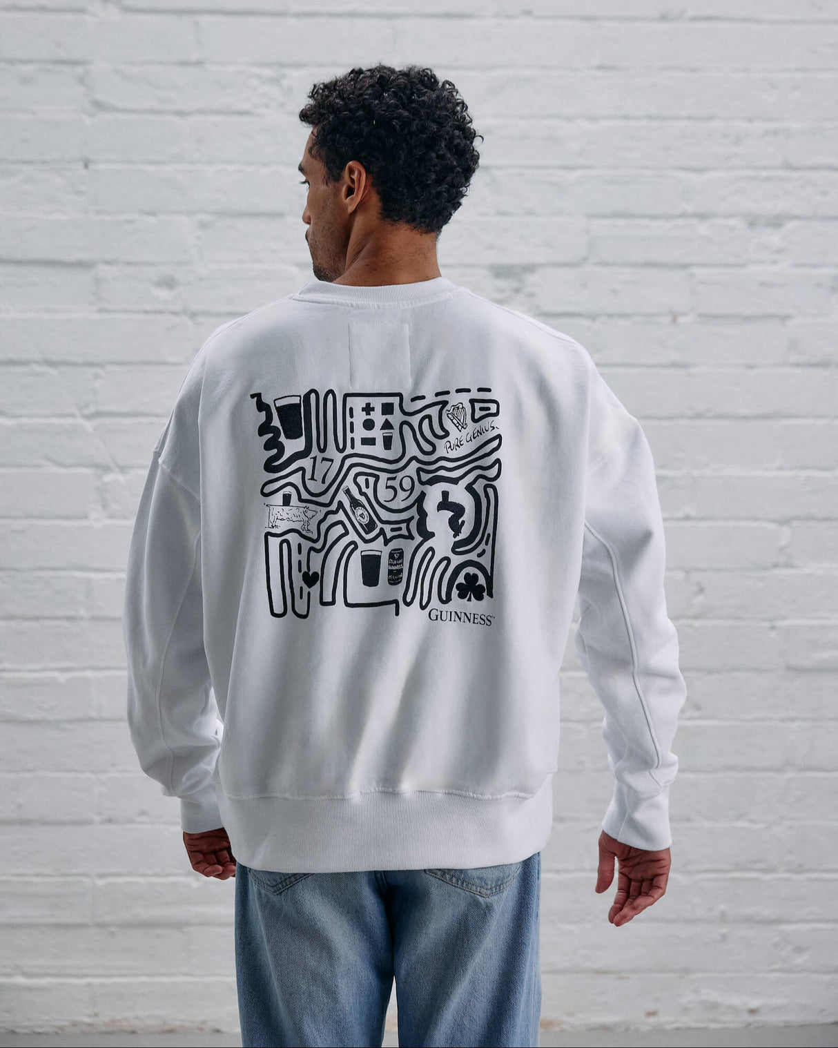 Model wearing the Guinness Storehouse Exclusive white Sweater with stylized Dublin map.