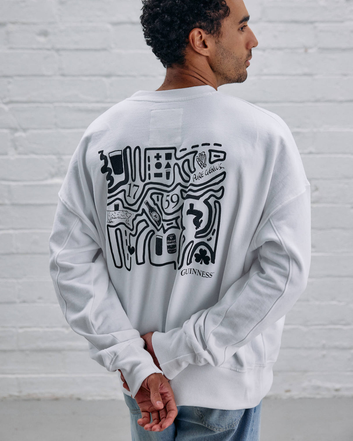 Model wearing the Guinness Storehouse Exclusive white Sweater with stylized Dublin map.