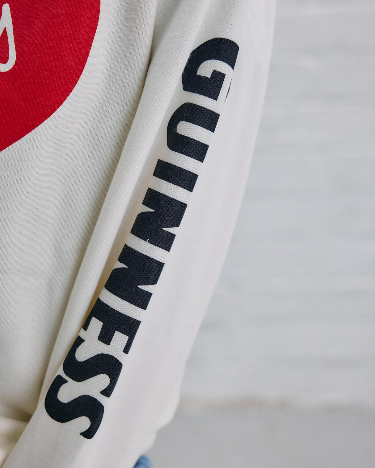 Close up image of the Guinness Storehouse Exclusive white sweater with the lovely day heart sleeves.