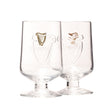 Two clear embossed goblet glasses with the Guinness harp logo on the stem.