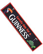 A rectangular Guinness PVC bar mat with red and green trim. It features the iconic Guinness toucan and text 'Lovely day for a GUINNESS' as well as an image of a turtle.