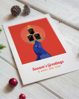 Holiday card with a blue bird and festive elements on a wooden surface
