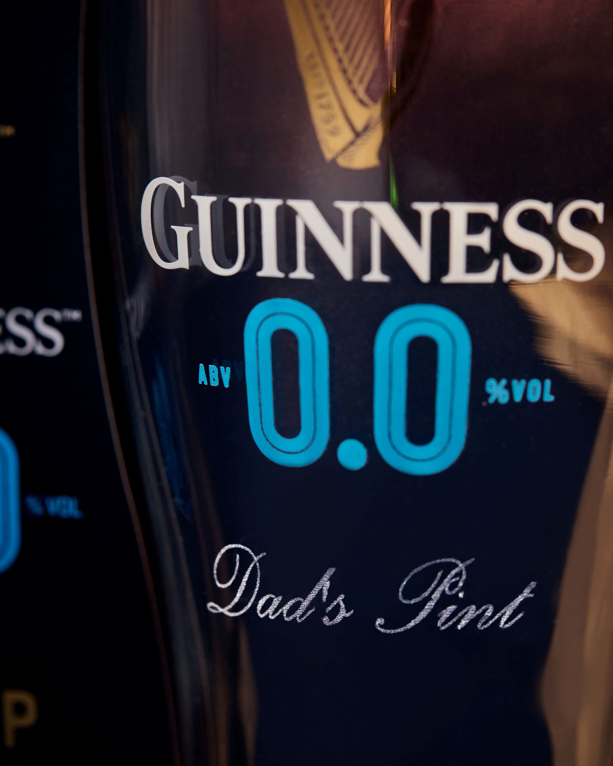 Guinness non-alcoholic pint glass with 'Dad's Pint' text on a dark background