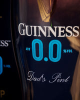 Guinness non-alcoholic pint glass with 'Dad's Pint' text on a dark background