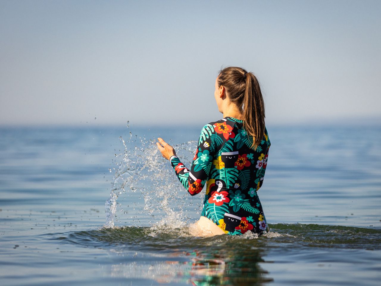 A girl swimming in the Irish sea with the new Guinness x Fatti Burke colourful pattern swimsuit. 
