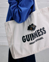 Model wearing the Guinness x Awave Apparel exclusive reusable bag featuring the Kick Off Time is Guinness Time.