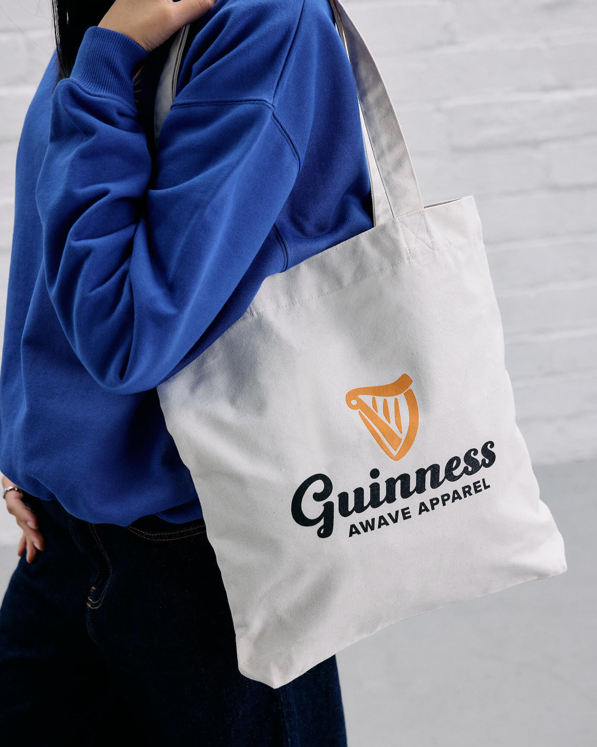 Model wearing the Guinness x Awave apparel milk carton reusable bag.