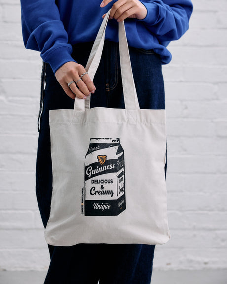 Model wearing the Guinness x Awave apparel milk carton reusable bag.