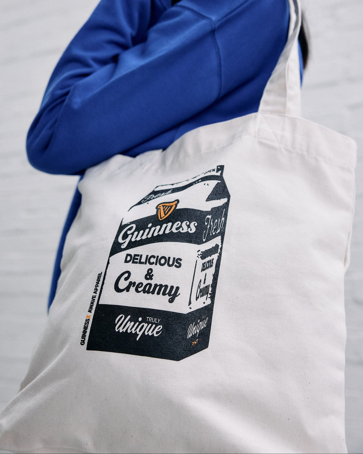 Model wearing the Guinness x Awave apparel milk carton reusable bag.