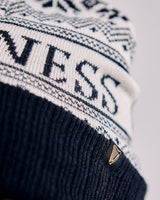 Person wearing a black and white knit beanie with 'Guess' branding.