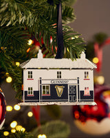 Guinness storehouse ornament on a Christmas tree with blurred lights in the background