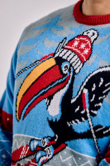 Close-up of a sweater with a colorful toucan design on a blue background.