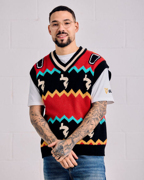 Man wearing a colorful patterned sweater vest over a white shirt against a light gray background